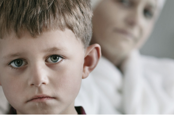 Little boy looking sad sitting with his terminally ill mother