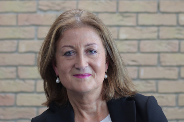 Professor Eilish Gilvarry sitting in front of brick wall.